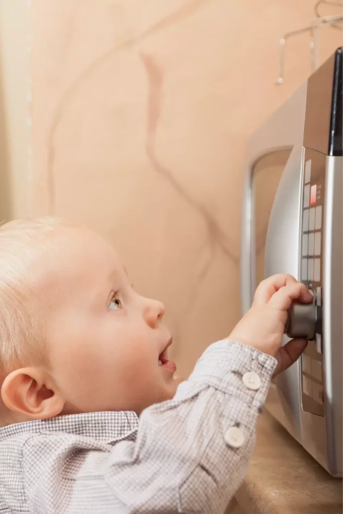 child playing with microwave oven
