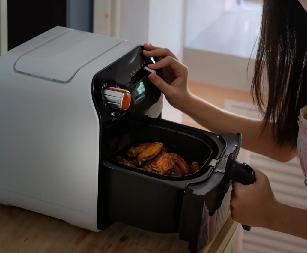 Air fryer with chicken wings inside